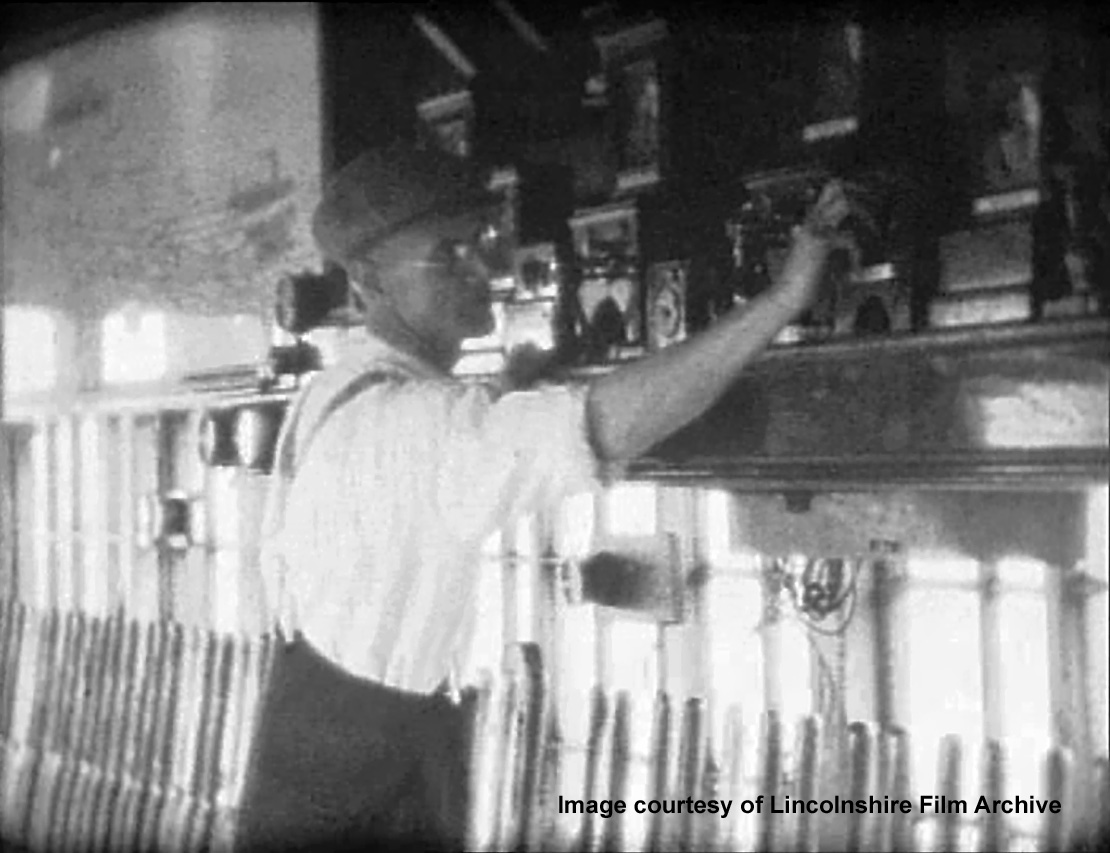 The signalman is communicating with one of the neighbouring boxes by special code using electric bells. From a film shot by Walter Lee. © Lincolnshire Film Archive