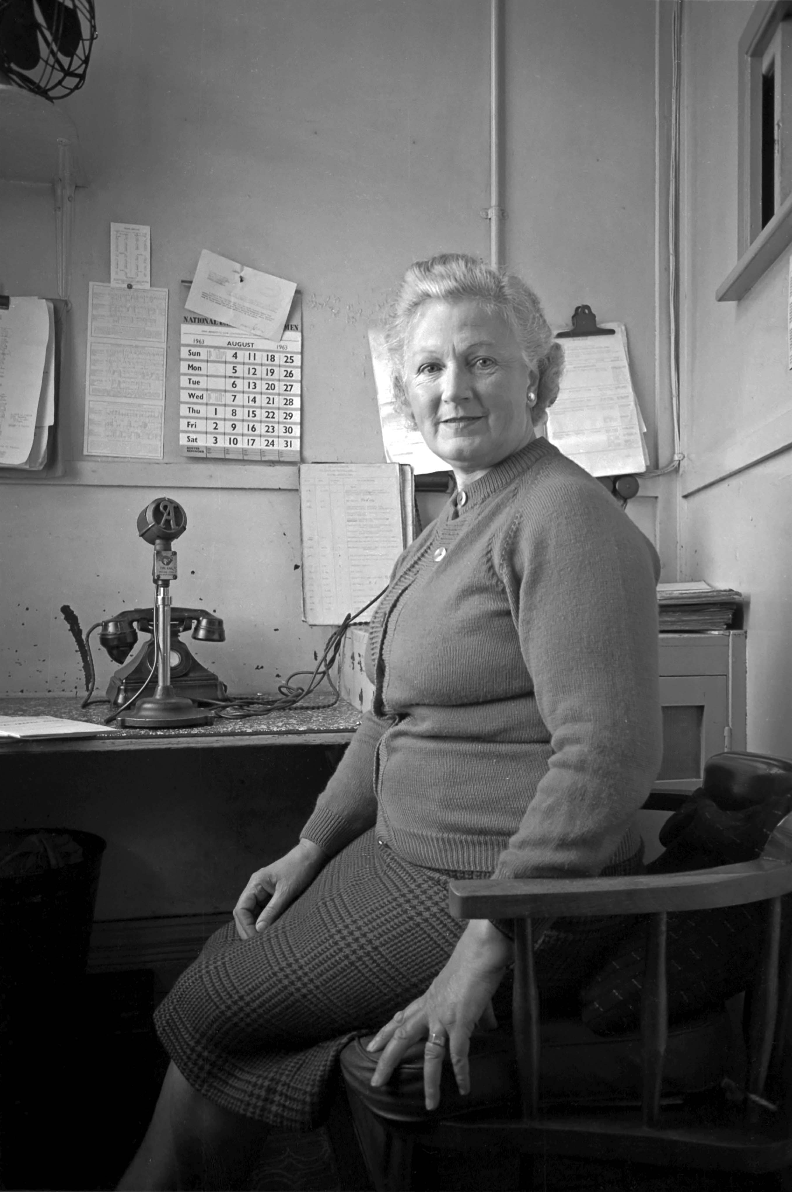Station Announcer Dorothy Ross on 22nd August 1963. Station announcers are ‘heard but not seen’. At Grantham they were confined in a this tiny room. The Railway Review / National Union of Railwaymen calendar is a reminder of the importance to railway staff of their trades unions. Photograph by Cedric A. Clayson, © John Clayson