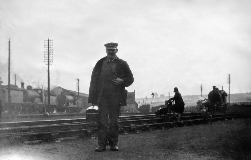 Driver Ernie Parr, a distant relative, showed Peter round the sheds at Grantham when he was a schoolboy and he had already set his mind on getting a job at the Loco. Behind Ernie is the ramp leading to the coal stage. There is no sign of the coaling plant, so the photograph must date from before 1937. On the right a woman is crossing the tracks with a child in a push chair. Peter thinks she will be going to the office to collect wages due to her husband (or perhaps a brother or her father). Close examination shows that the child is holding onto a shopping basket and they are being followed by a dog! Ernie retired on the same day that Peter started working at the Loco. He is carrying a metal toolbox. "All the drivers had them," Peter told me. Photograph lent by Peter Wilkinson.