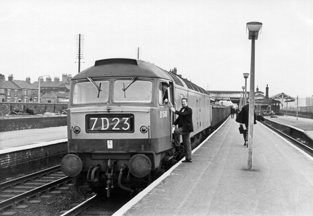 Brush Type 4 locomotive No.D1540 on 7D23, a loaded ironstone train, has stopped in the Down Main line platform at Grantham for a crew change. Driver Jim Willetts, walking down the platform on the right, has brought the train from Highdyke. Relieving him and preparing to take it forward are Driver Stan Nichols (in the cab) and Secondman Jake Garland. The date of this photograph is not known but it would be the mid-1960s. Photograph lent by Ken Willetts (Jim's son).