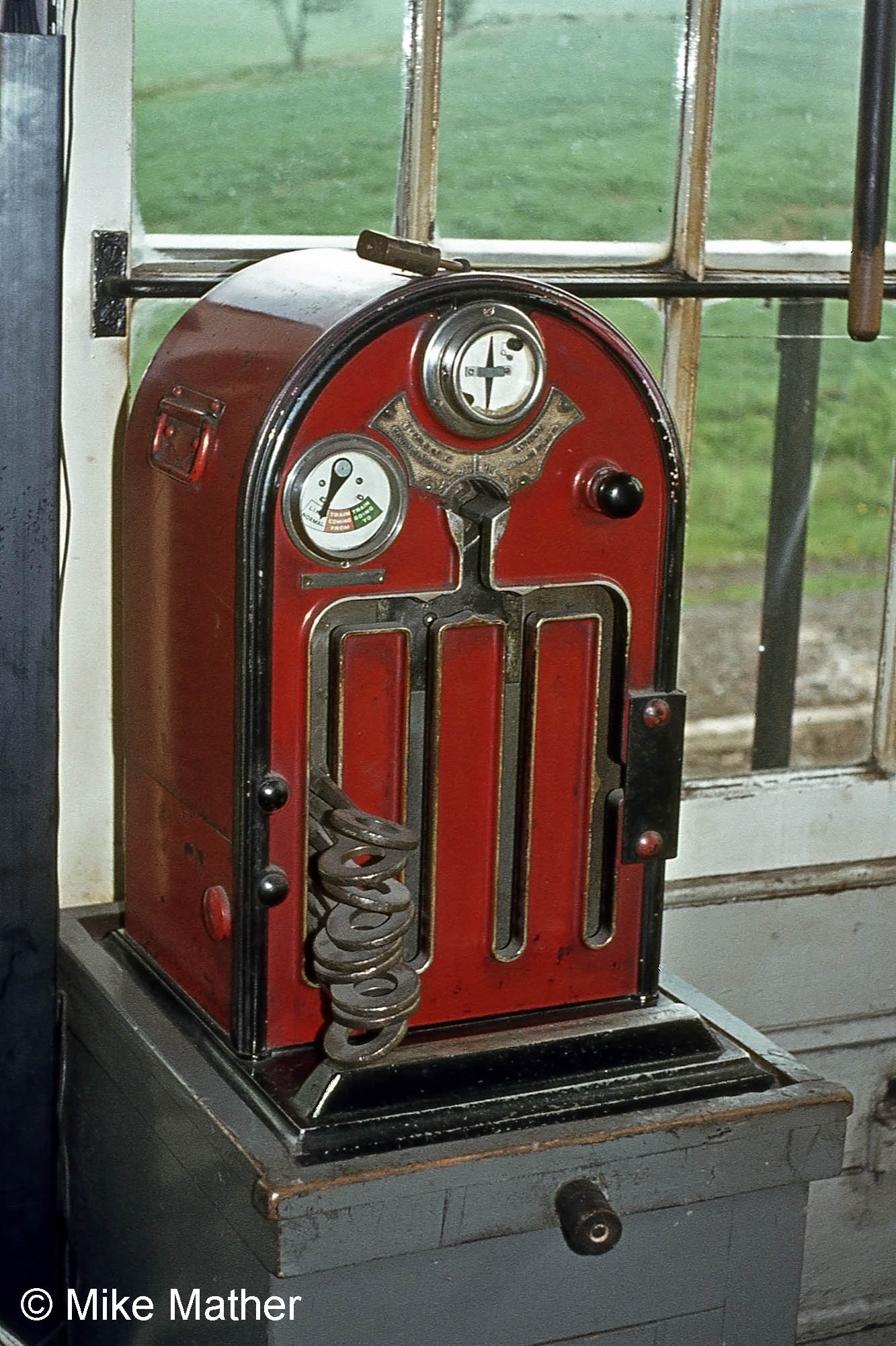 The Tyers Electric Key Token instrument at High Dyke. This instrument allowed a key token to be issued to the driver of a train which was to travel on the single line to Colsterworth as authority to use the single line. There was an identical instrument at Colsterworth signal box, and the two were electrically connected so that only one key token could be removed from the pair of instruments. Once a key token has been withdrawn from either instrument both instruments become locked until the token is replaced in eithe of them. Thus a driver who has been given a token knows that there can be no other train on the section. Photograph by Mike Mather 