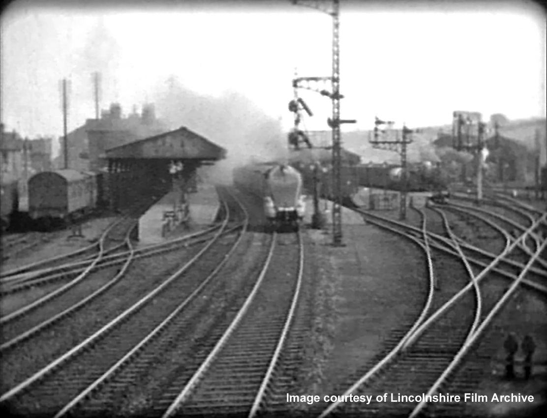 Here is the signalman’s commanding view of the north end of the station, as seen in 1937. The approaching train is thought to be the inaugural streamlined high speed Coronation service of 5th July, non-stop from London King’s Cross to Edinburgh Waverley, passing Grantham soon after 5.30pm. Taken from a cine film shot by photographer and film maker Walter Lee of Grantham. © Lincolnshire Film Archive