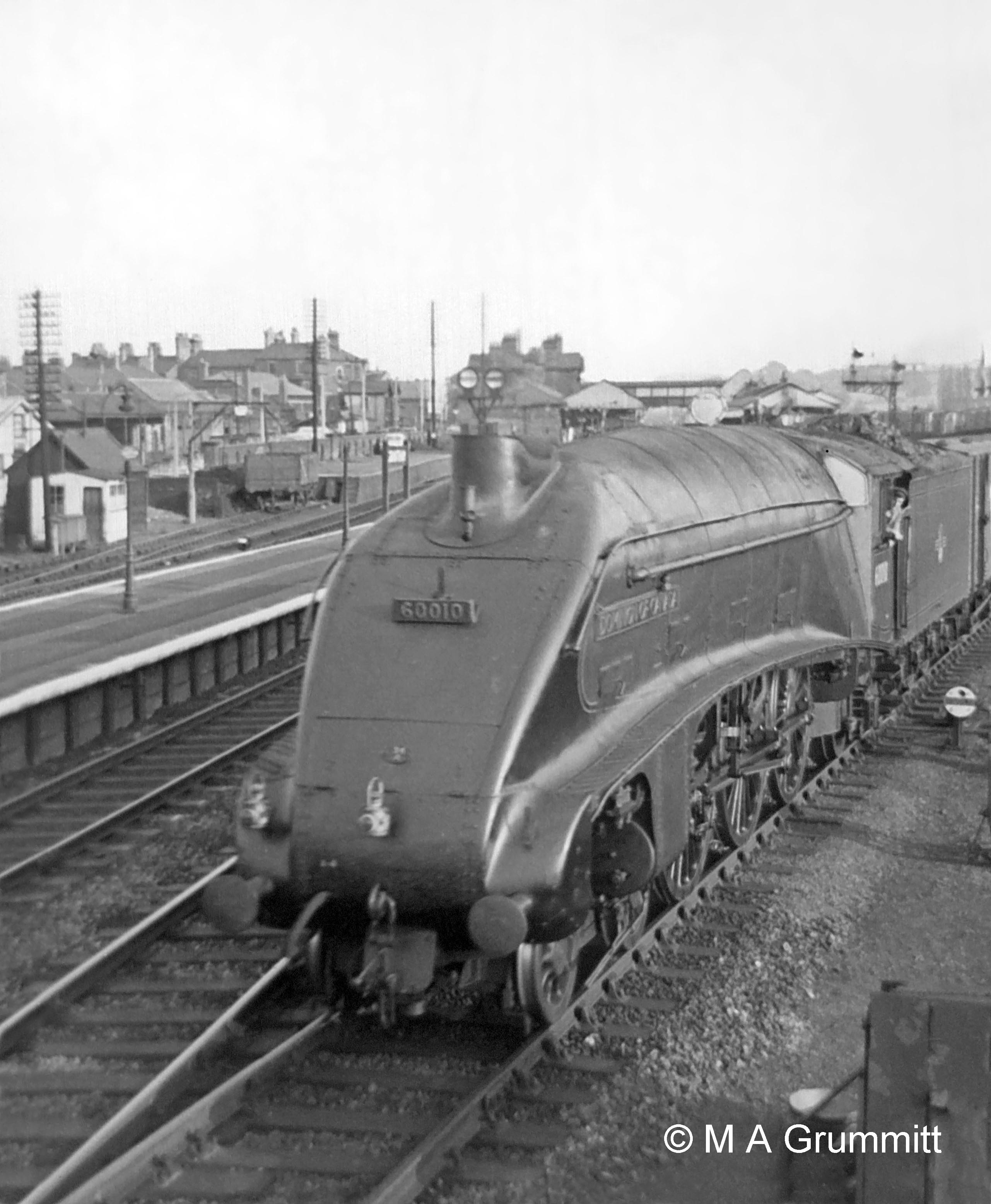Here is train No. 266, the ‘Scotch Goods’ from King’s Cross Goods Yard to Niddrie in Edinburgh, resuming it journey after stopping to take water on the Goods line. The fireman of this train would normally have refilled its tender at Werrington water troughs just north of Peterborough, and it would rattle through Grantham at speed on the Main line. On this occasion Werrington troughs were out of action for repairs so it was booked to stop at Grantham for water. No.60010 Dominion of Canada. Photograph by Mick Grummitt.