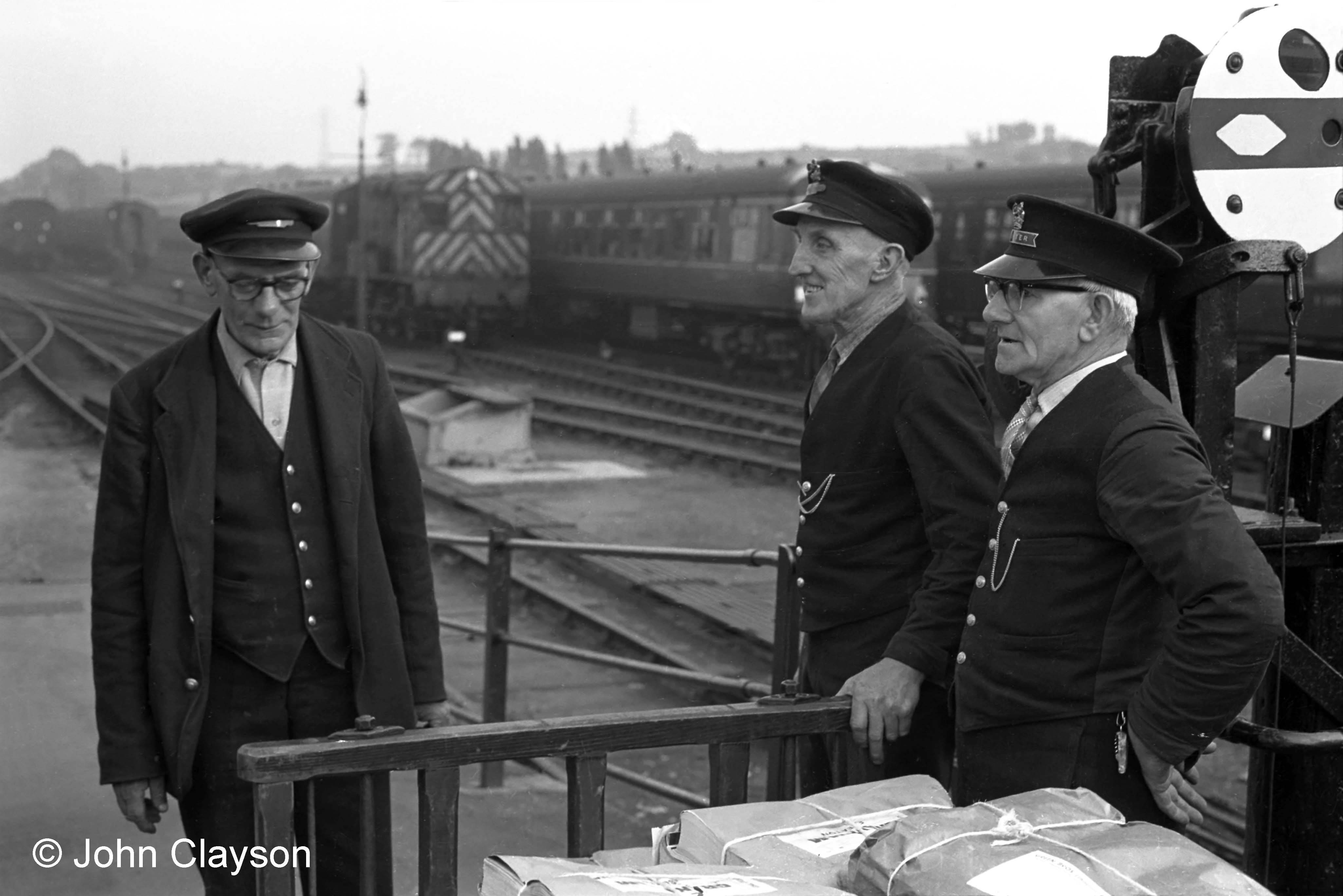 These three porters are at the south end of the down platform opposite the Yard Box, probably waiting for a train to pass before taking the trolley across the main line to the parcels office. The disc signal on the right enables the Yard Box signalman to control shunting movements out of the down main line platform. The porters are, left to right, Alf Woodward, Mr White and Bob Carpenter. Photograph taken on 27th June 1963 by Cedric A. Clayson.