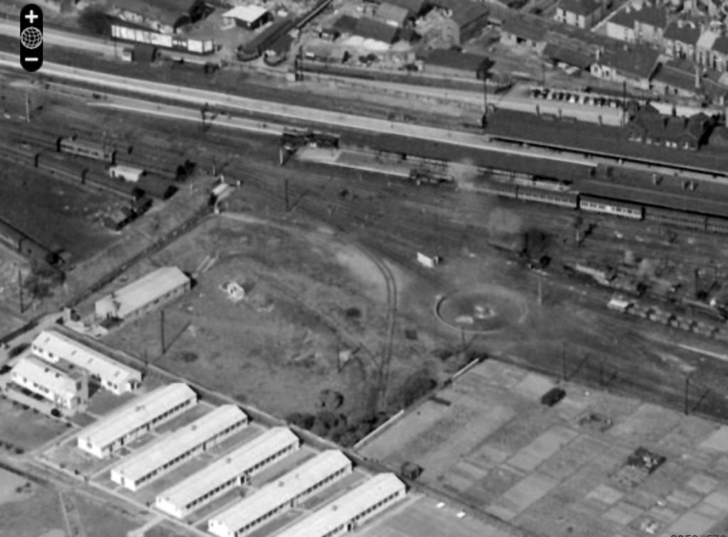 The building which became the first part of the BRSA Club in 1955 stands parallel to the footpath leading under the station, near the left hand edge of this view. The photograph was taken on 19th April 1950. The primary school now occupies the site of the buildings at bottom left. Just to right of centre is the abandoned turntable pit. The turntable had been taken out of use because of ground subsidence but the turning triangle next to the shed had not been constructed at this date. Locomotives requiring to be turned had to travel to Barkston Junction to use the triangle there. http://www.britainfromabove.org.uk/image/eaw028682 © Copyright English Heritage